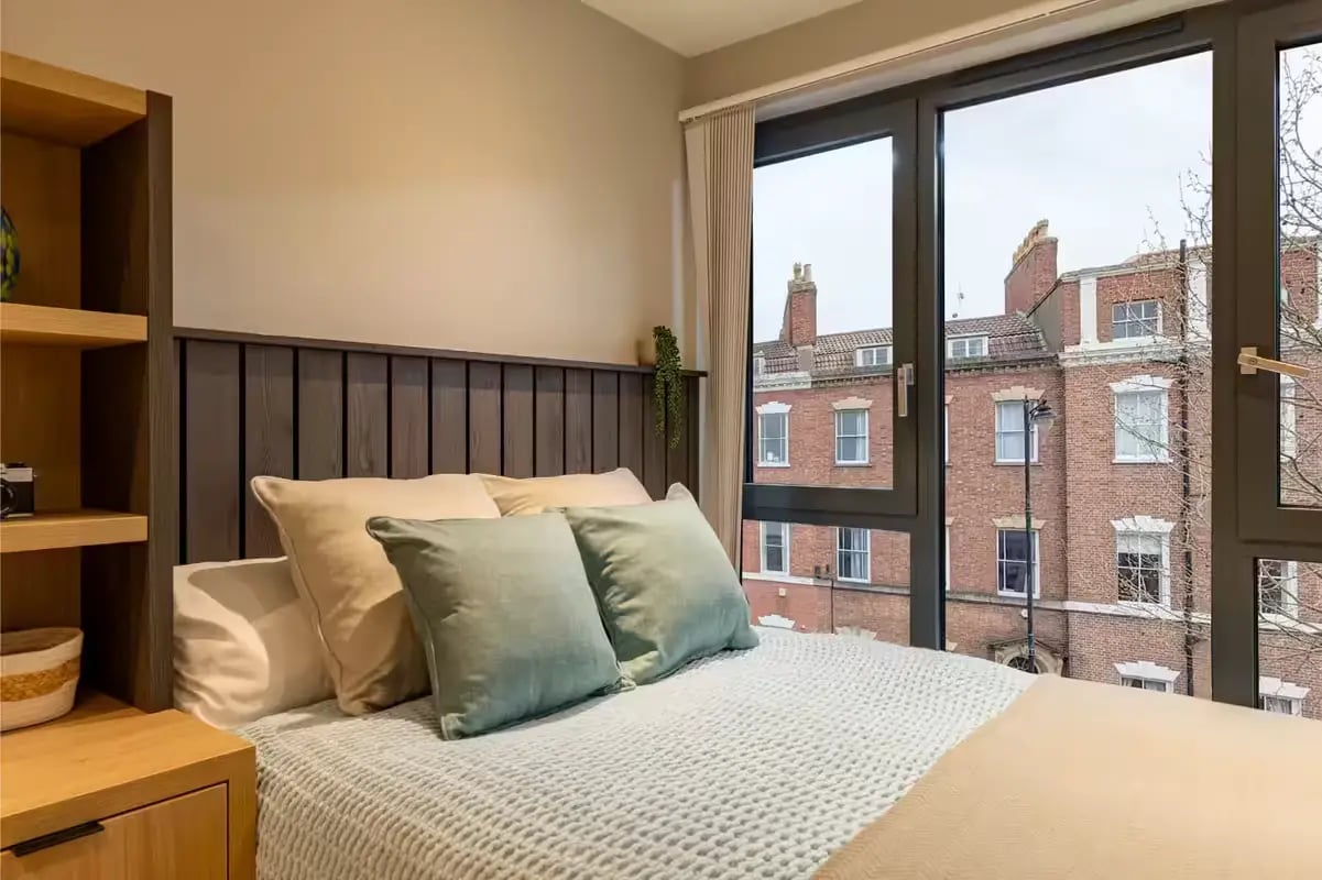 Bed pillows shelves and window bedroom at The Port On The Square in Bristol Student Accommodation