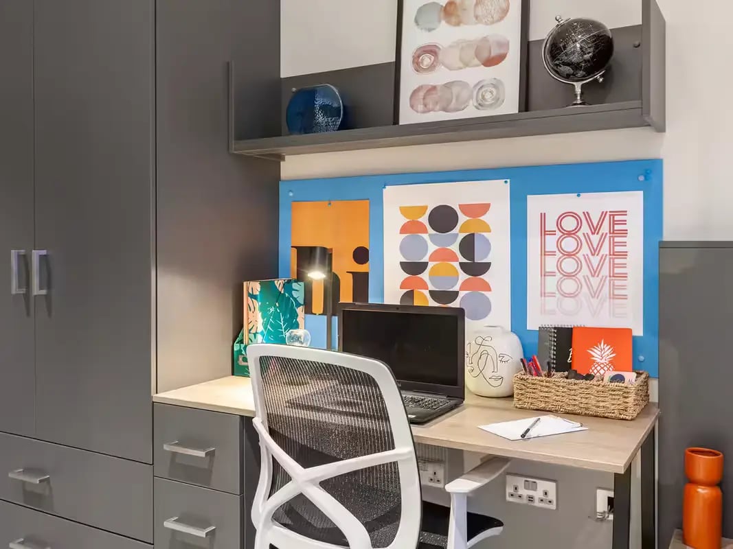 Desk with laptop chair art and storage study area at Grosvenor House in London Student Accommodation