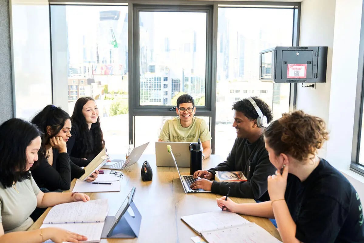 Students work and study at a communal table living room at UniLodge Royal Melbourne in Melbourne Student Accommodation
