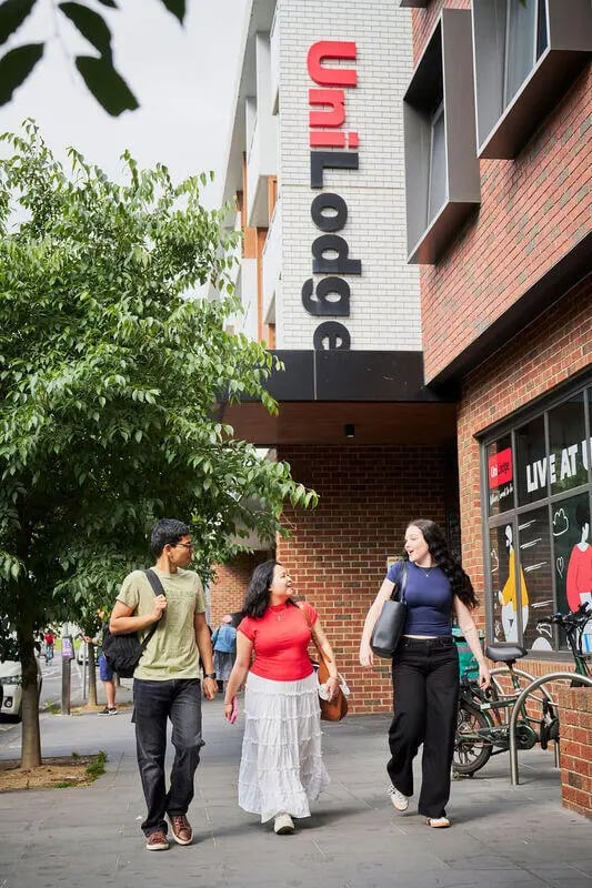 Students walk past building with UniLodge sign exterior at UniLodge Royal Melbourne in Melbourne Student Accommodation