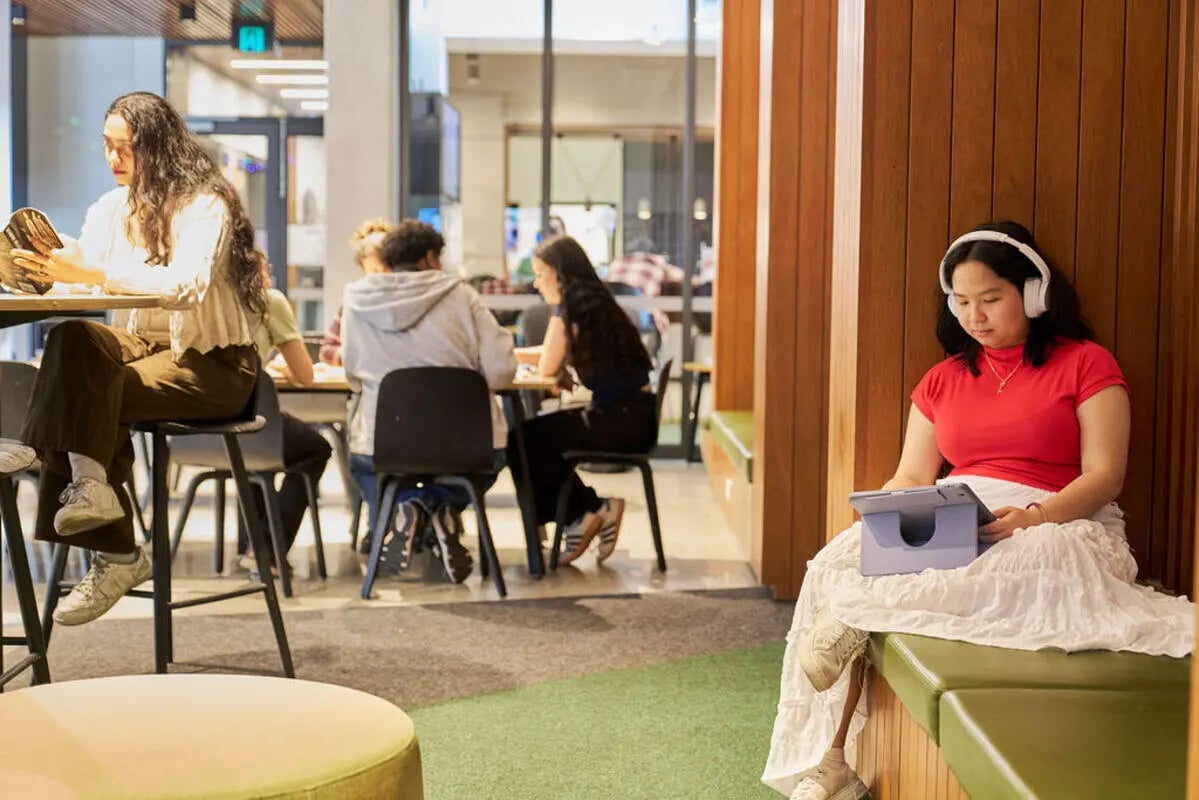 Students study at tables and on benches communal area at UniLodge Royal Melbourne in Melbourne Student Accommodation