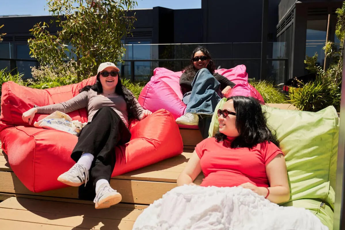 Three women on beanbags outdoors patio area at UniLodge Royal Melbourne in Melbourne Student Accommodation