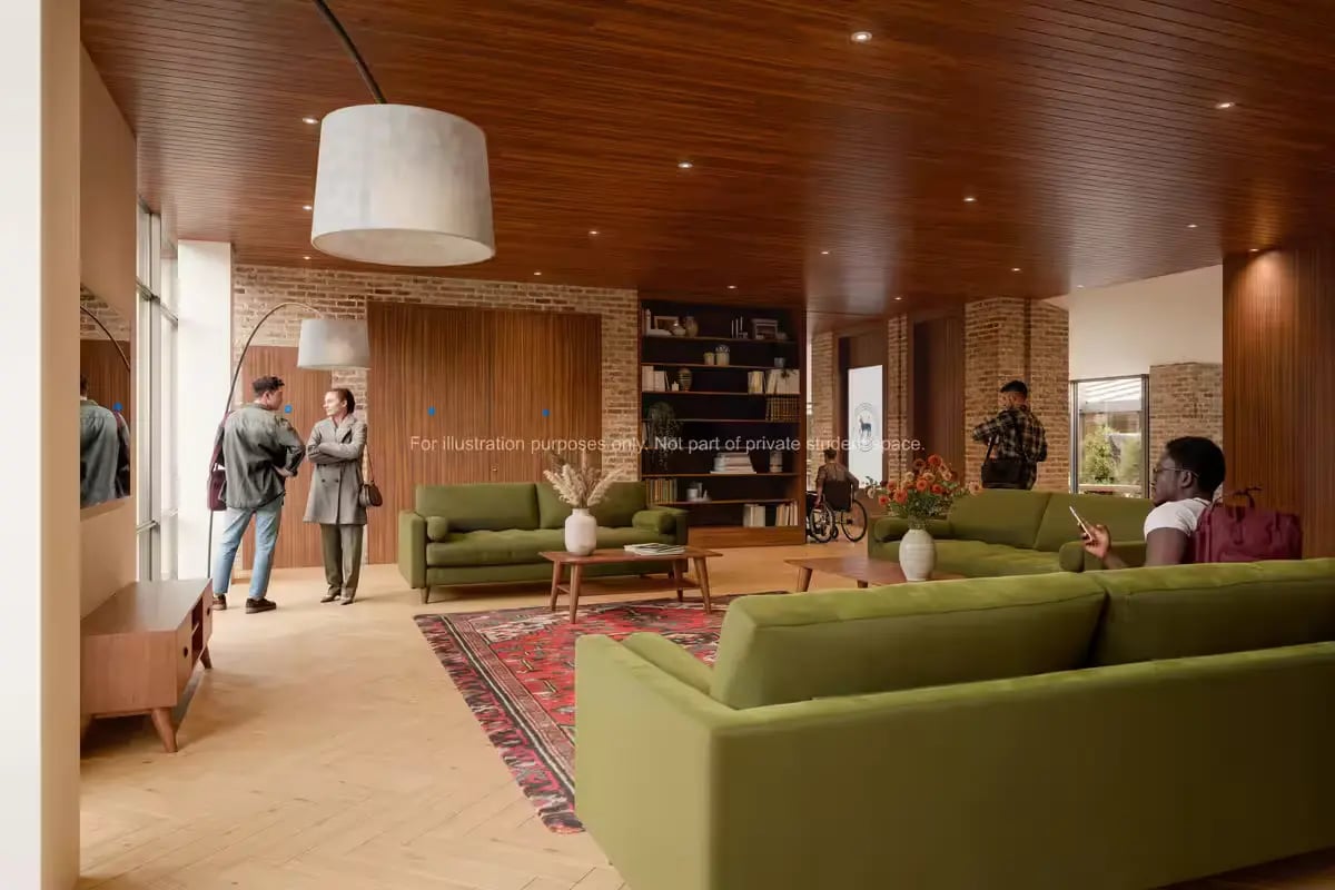 Green sofas bookshelves people and wheelchair communal living room at Ryan Hall in Belfast Student Accommodation