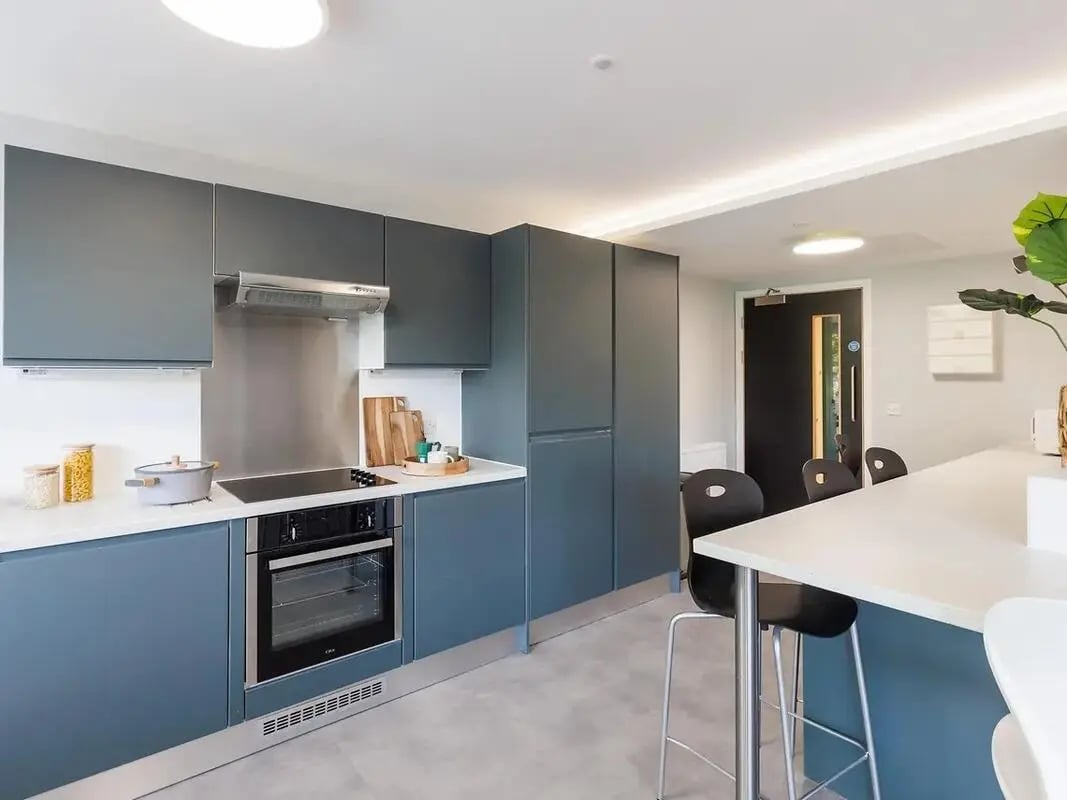 Modern kitchen with grey cabinets oven stovetop and island kitchen at Element Bermondsey in London Student Accommodation
