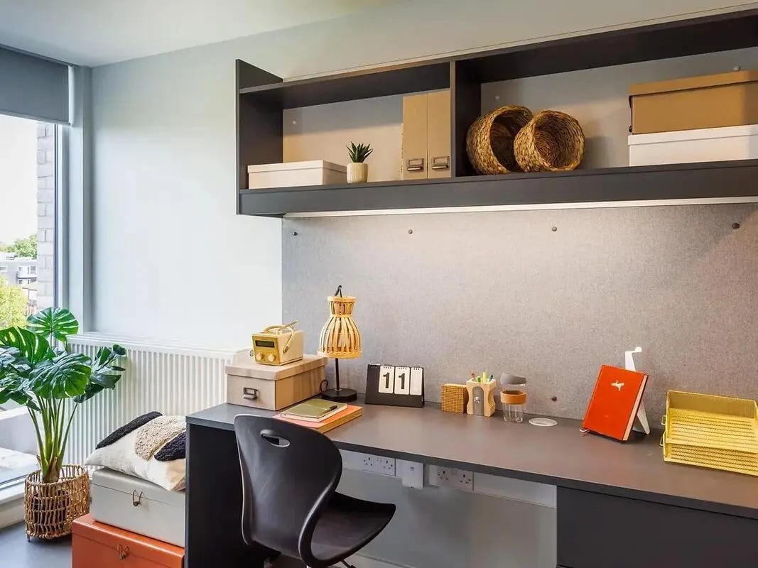 Desk with chair lamp calendar and plant study area at Element Bermondsey in London Student Accommodation