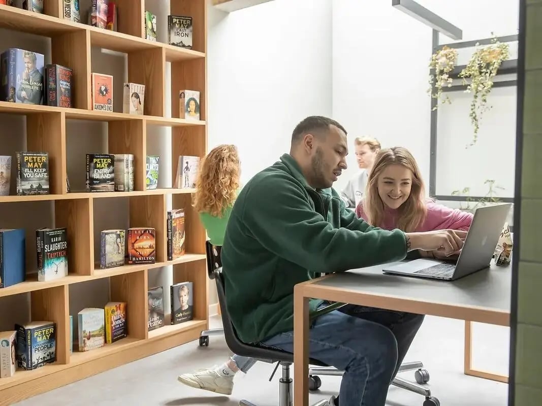 Students study on laptops in library study area at Element Bermondsey in London Student Accommodation