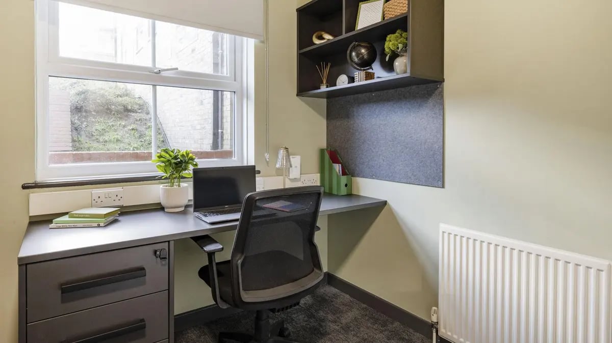 Desk chair laptop books shelving study area at Dean House in London Student Accommodation