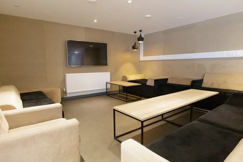 Sofas television and tables communal lounge at AXO New Cross in London Student Accommodation