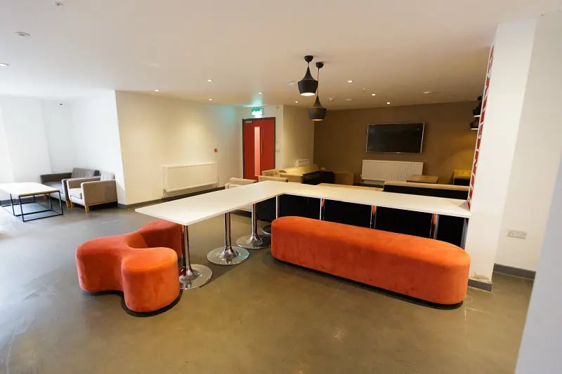 Modern lounge with sectional seating and large table lounge at AXO New Cross in London Student Accommodation