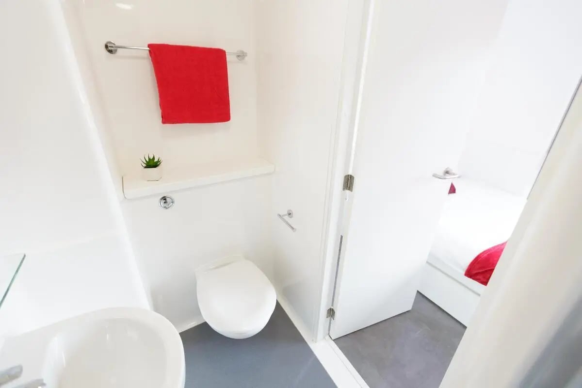Toilet sink red towel bedroom glimpse bathroom at AXO New Cross in London Student Accommodation