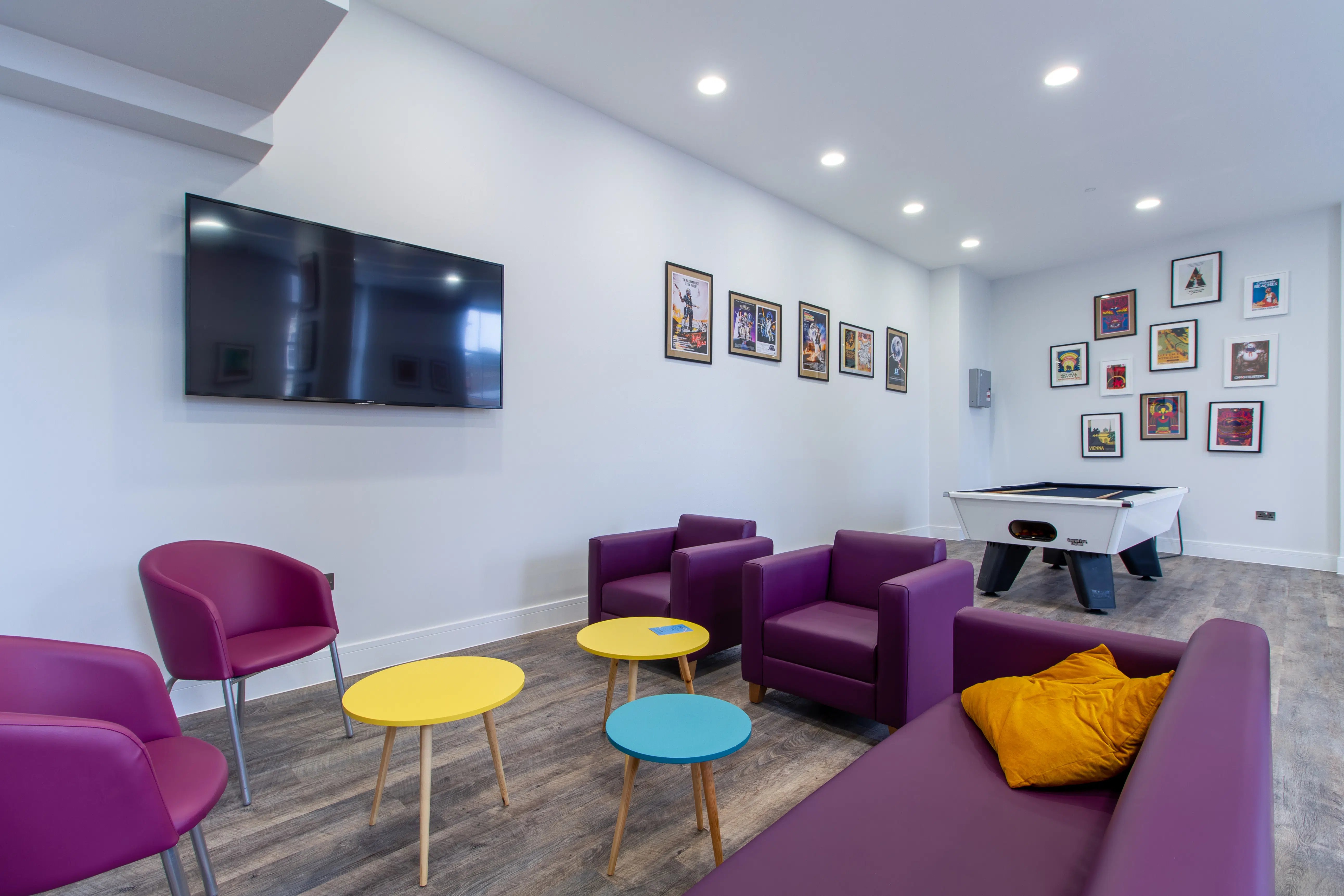 Purple armchairs TV and pool table living room at AXO Seven Sisters in London Student Accommodation