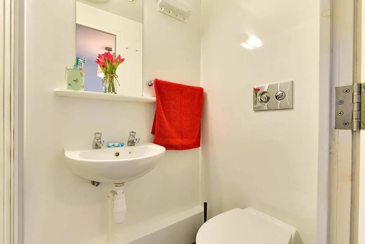 Sink toiletries red towel toilet cistern bathroom at AXO Islington in London Student Accommodation