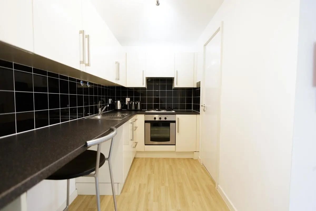 White cabinets black backsplash modern oven kitchen at AXO Islington in London Student Accommodation