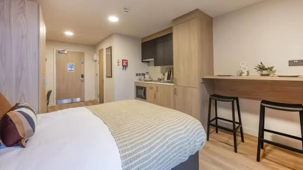 Bed kitchen area with stools study area at Haymarket Yards in Edinburgh Student Accommodation