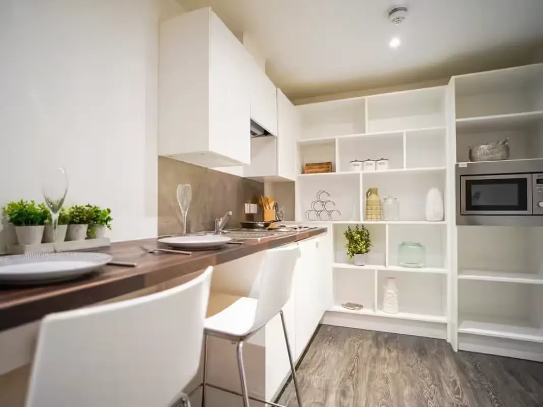Two white chairs on wooden counter kitchen at Gallery Apartments in Glasgow Student Accommodation