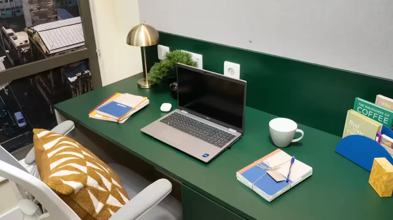 Desk with laptop notebooks lamp coffee mug study area at St Vincent Studios in Glasgow Student Accommodation