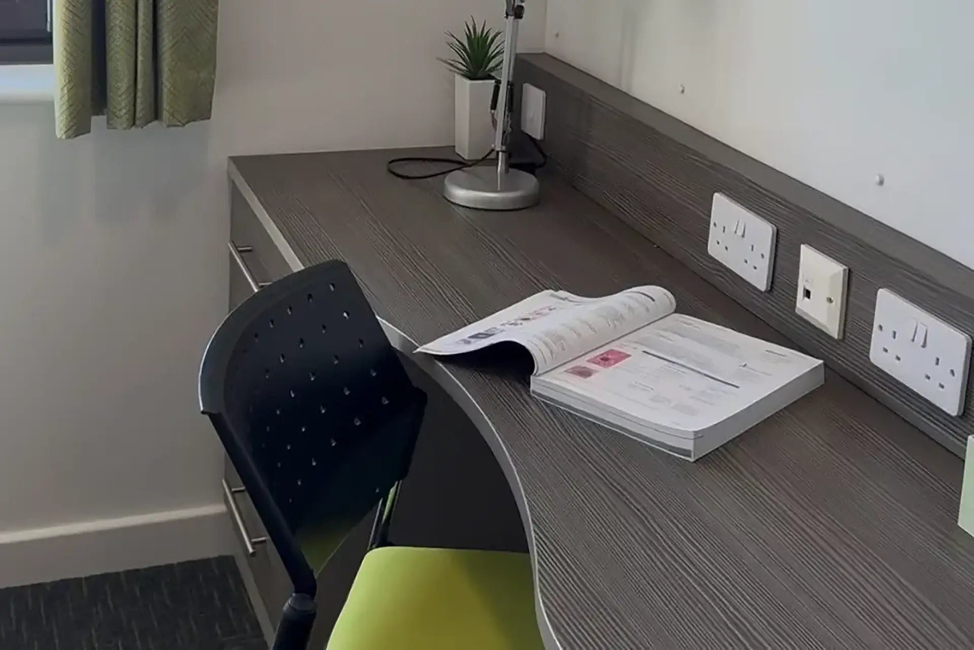 Desk lamp chair open book wall sockets study area at Friargate Court in Preston Student Accommodation