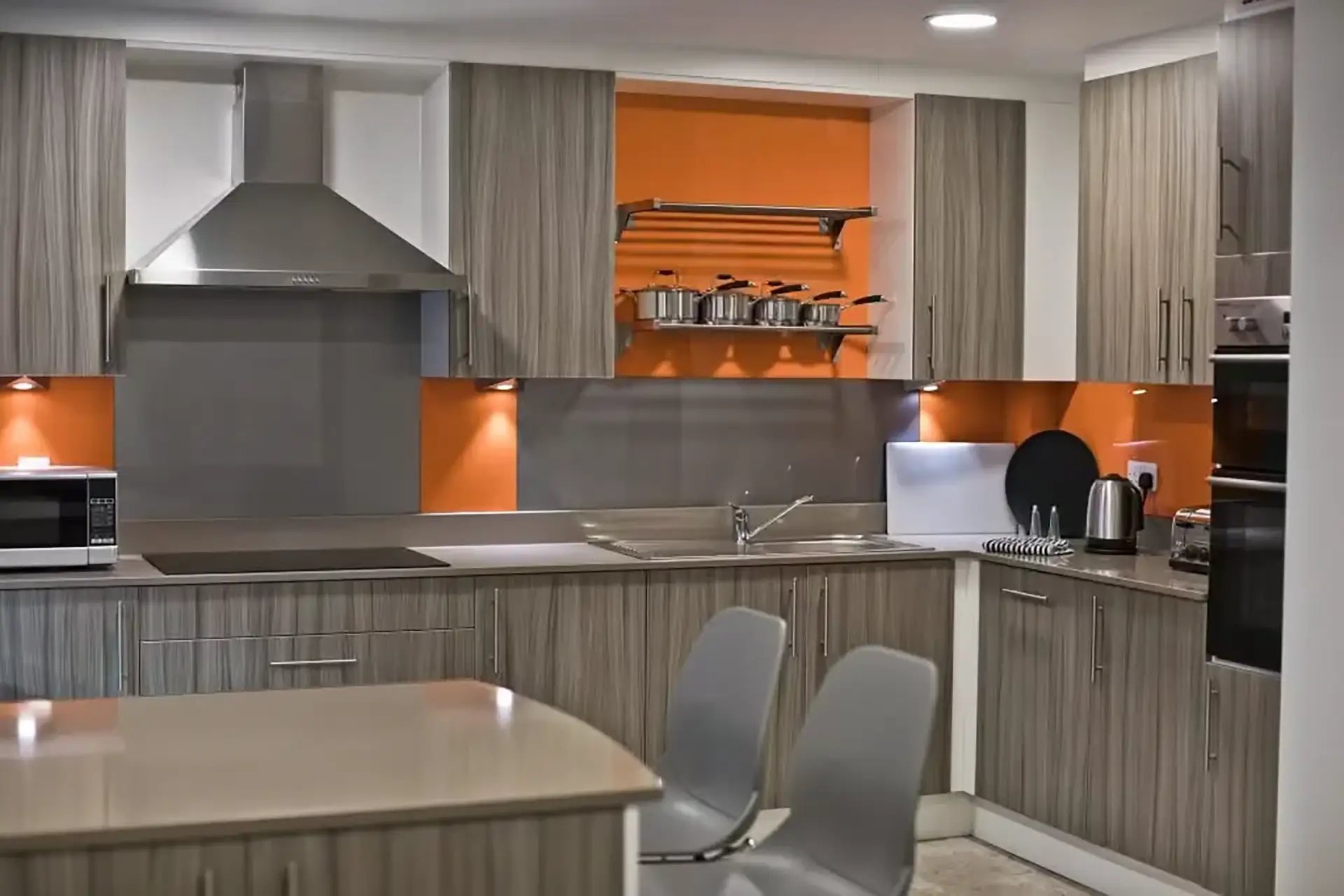 Modern kitchen with grey cabinets and orange backsplash kitchen at Friargate Court in Preston Student Accommodation