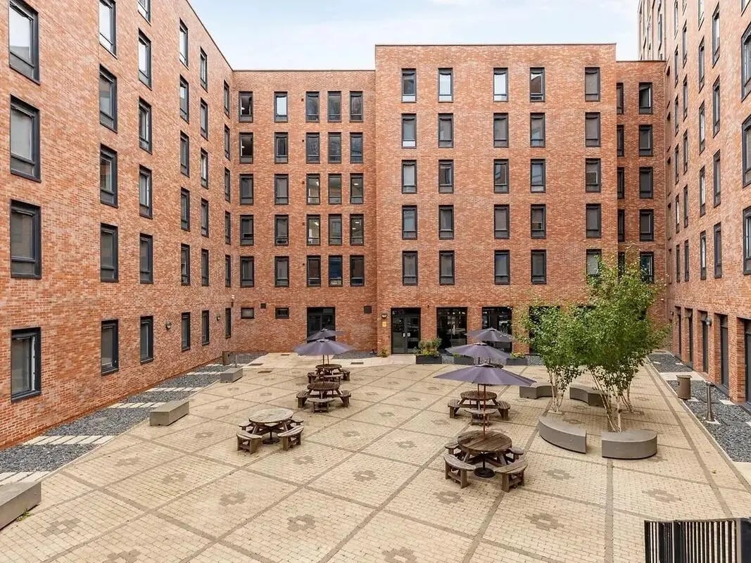Picnic tables under umbrellas courtyard exterior at Globe Works in Birmingham Student Accommodation