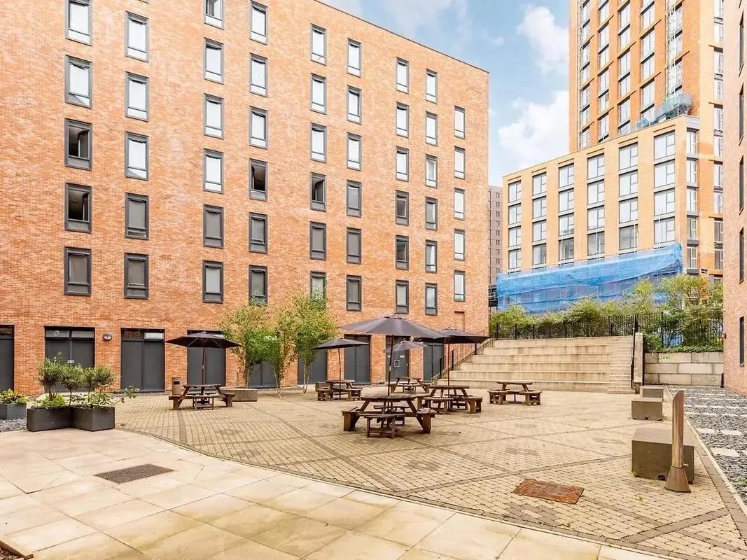 Courtyard with picnic tables umbrellas exterior at Globe Works in Birmingham Student Accommodation