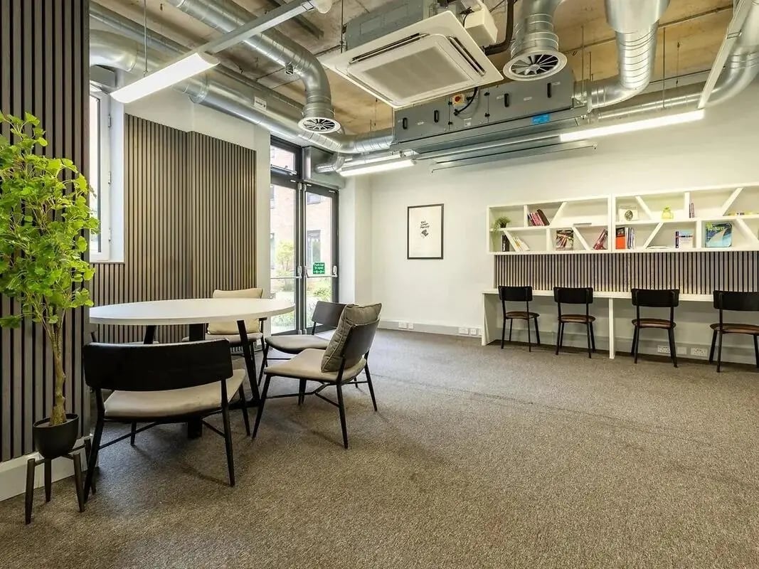 Round table chairs plant study area with shelves at Globe Works in Birmingham Student Accommodation