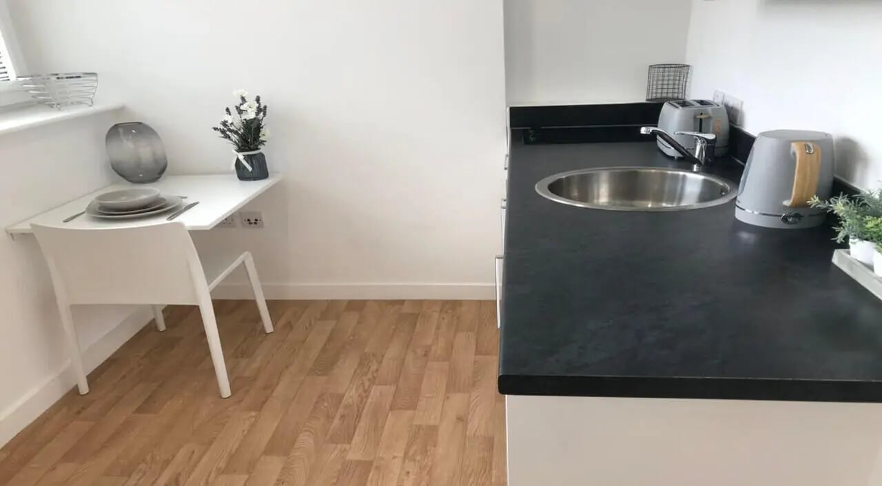 Fold-out table plates chair kettle sink kitchen at Keele House in Newcastle Under Lyme Student Accommodation