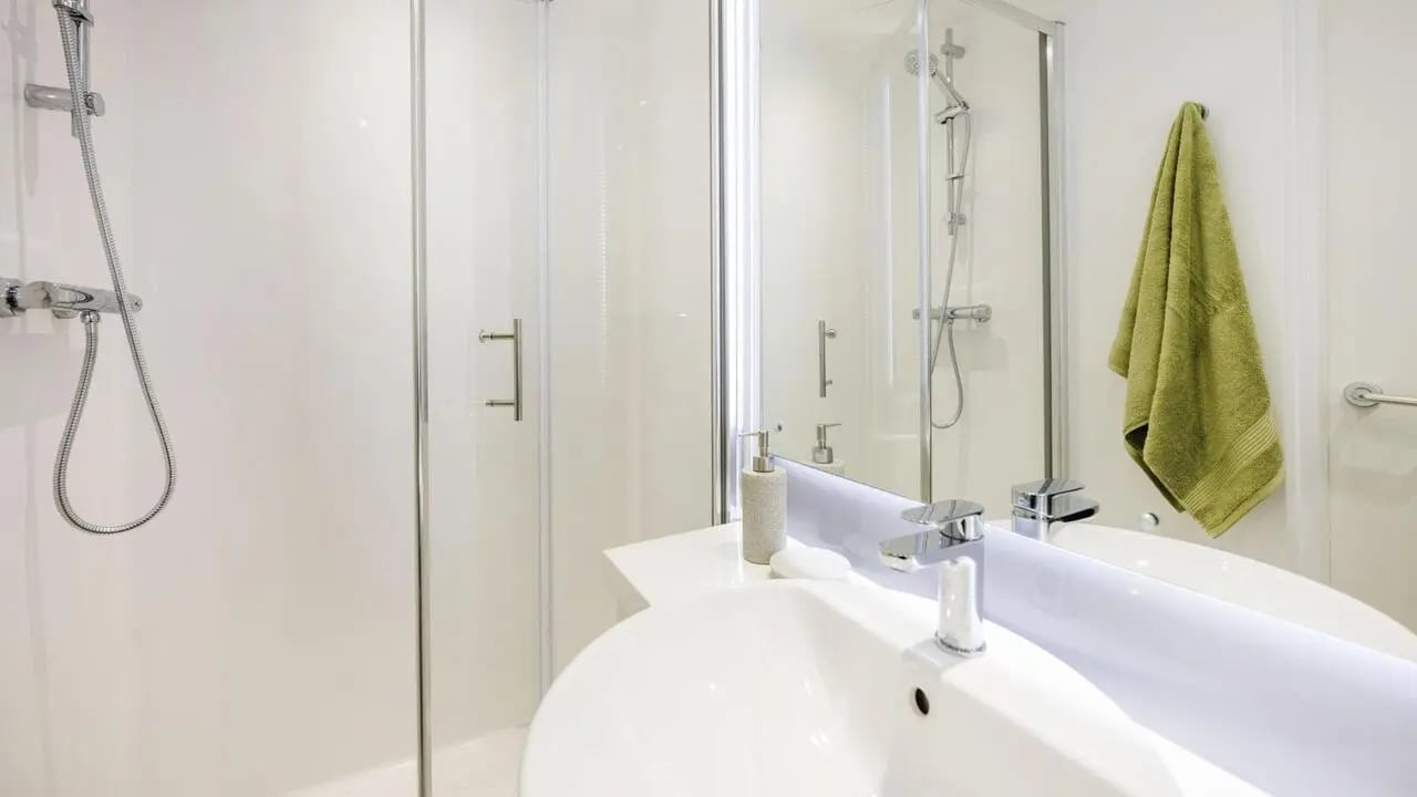 Shower sink soap dispenser and towel bathroom at St Gabriels in Manchester Student Accommodation