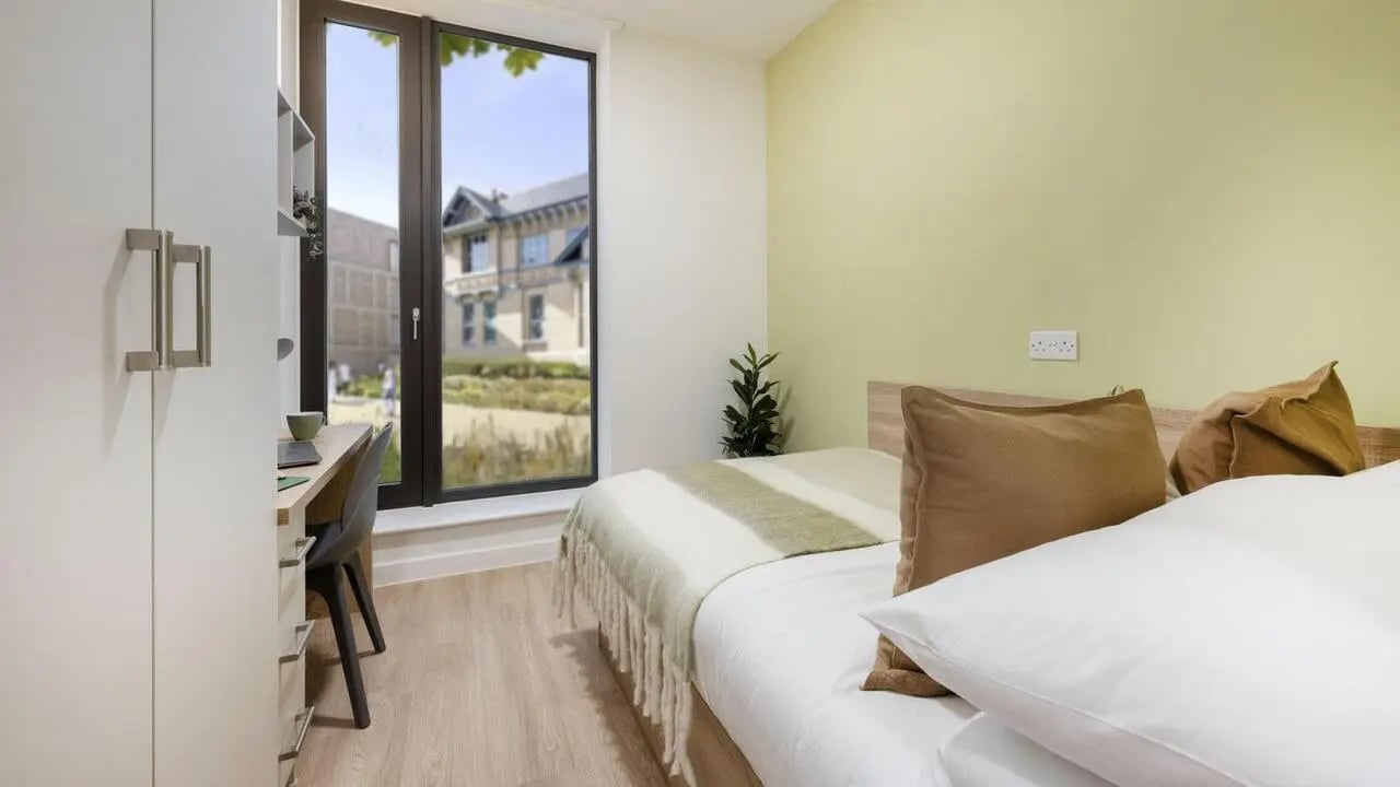 Bed desk wardrobe green wall bedding bedroom at St Gabriels in Manchester Student Accommodation