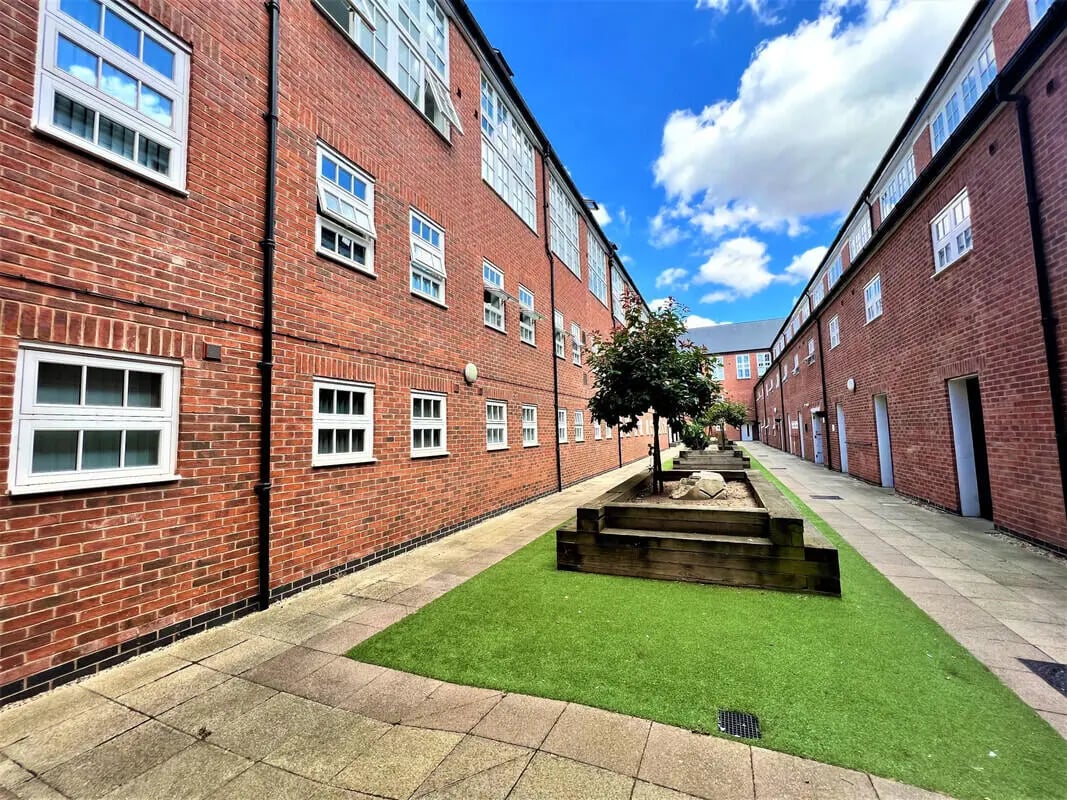 Brick building with artificial grass courtyard exterior at Tudor Studios in Leicester Student Accommodation