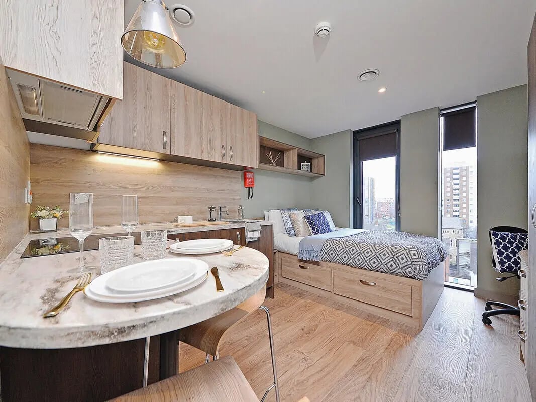 Kitchen area with dining table and bed Bedroom at Fontenoy Apartments in Liverpool Student Accommodation