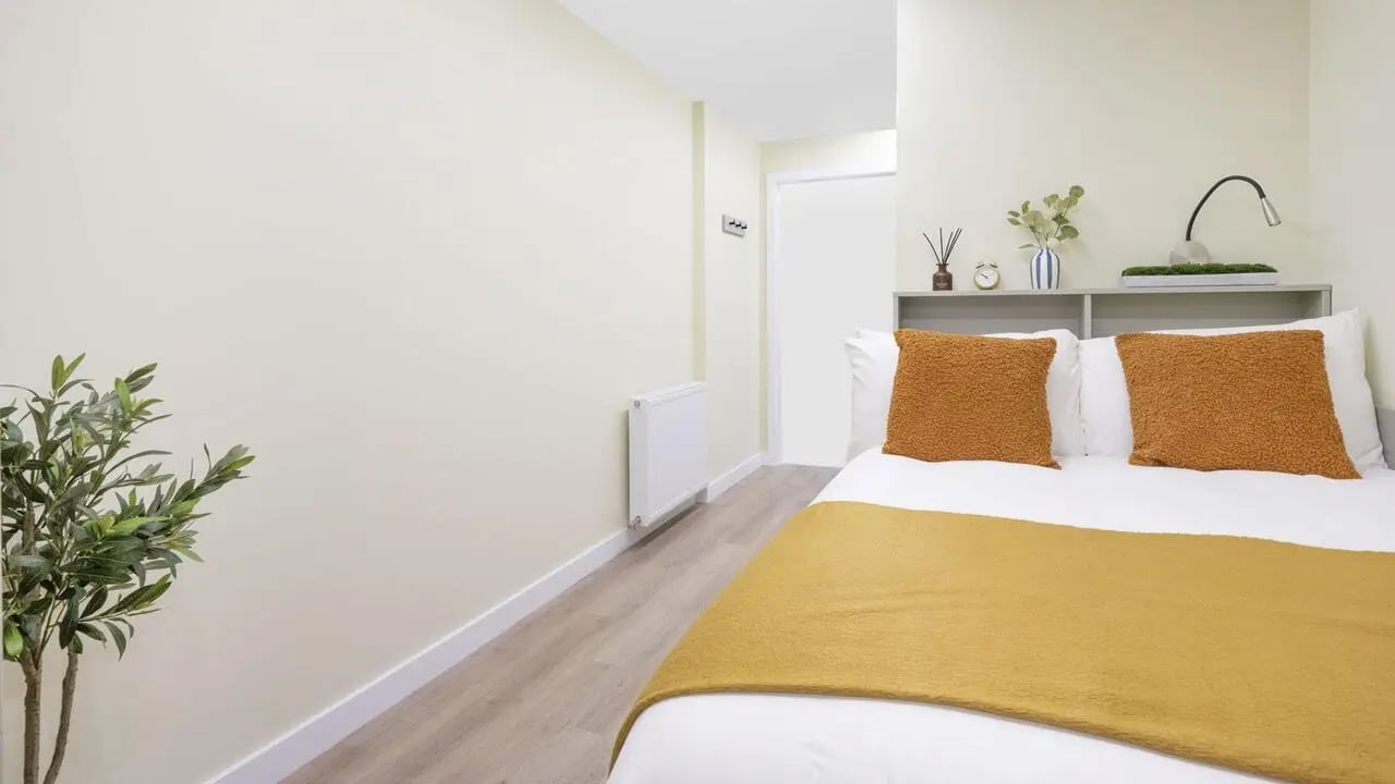 Bed with pillows and plant bedroom bedroom at St Vincent Studios in Glasgow Student Accommodation