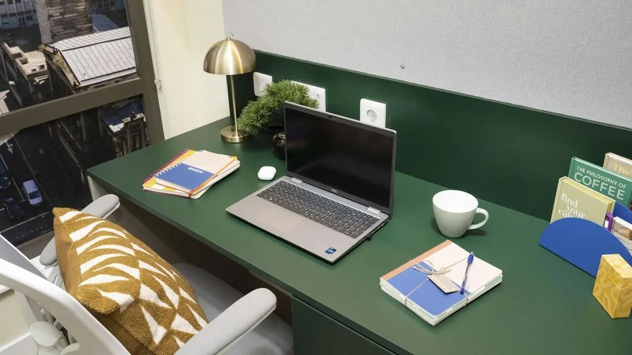 Desk with laptop notebooks lamp and coffee cup study area at St Vincent Studios in Glasgow Student Accommodation