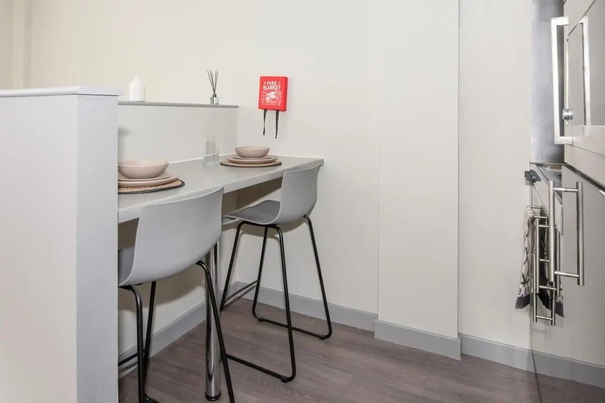 Table with chairs and fire blanket kitchen at Studio 58 in Bristol Student Accommodation