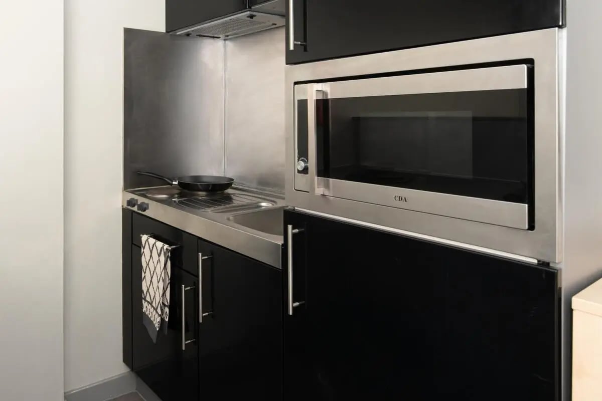 Sink stove microwave black cabinets towel kitchen at Studio 58 in Bristol Student Accommodation