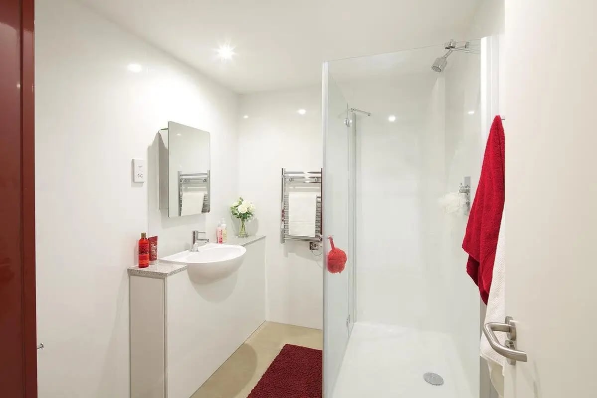 Sink mirror shower towel red mat bathroom at Wood Lane Studios in London Student Accommodation