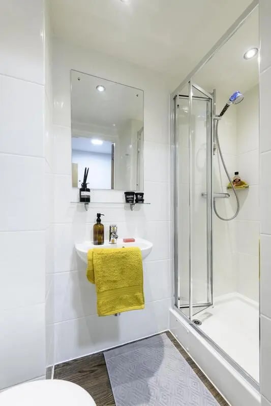 Sink shower and yellow towel bathroom at The Elements in Sheffield Student Accommodation