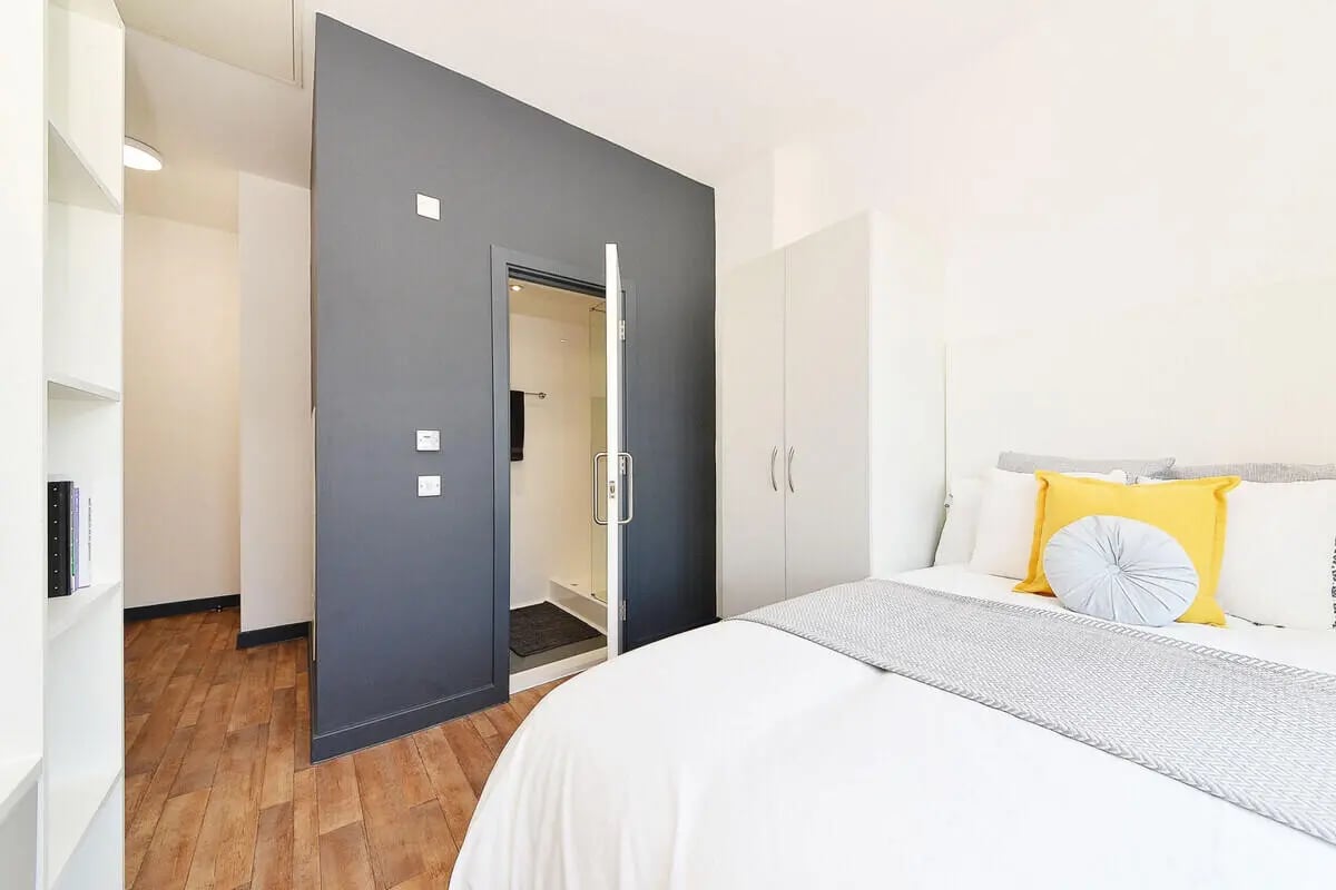 Bed with pillows wardrobe and ensuite bathroom Bedroom at Plymouth Cross House in Plymouth Student Accommodation
