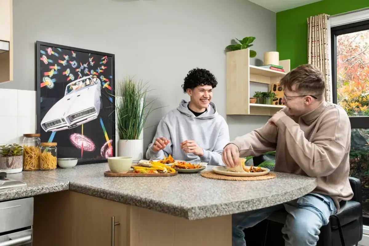 Two students eating at a kitchen counter living room at The Anvil in Sheffield Student Accommodation