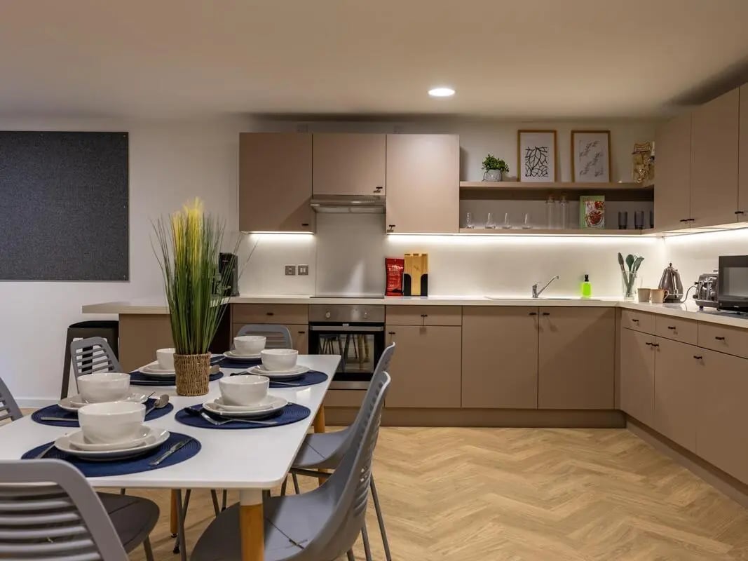 Dining table with place settings and kitchen area kitchen at Arcadian in Nottingham Student Accommodation