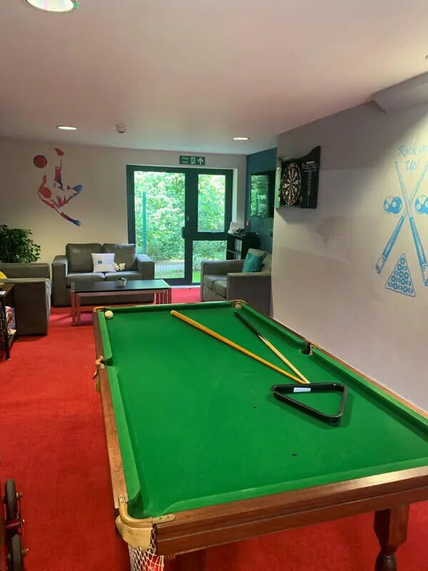 Pool table with cues and dartboard lounge area at Canterbury Student Village in Canterbury Student Accommodation