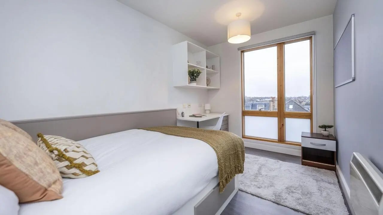 Bed desk shelves window rug bedroom at Charles Morton Court in London Student Accommodation
