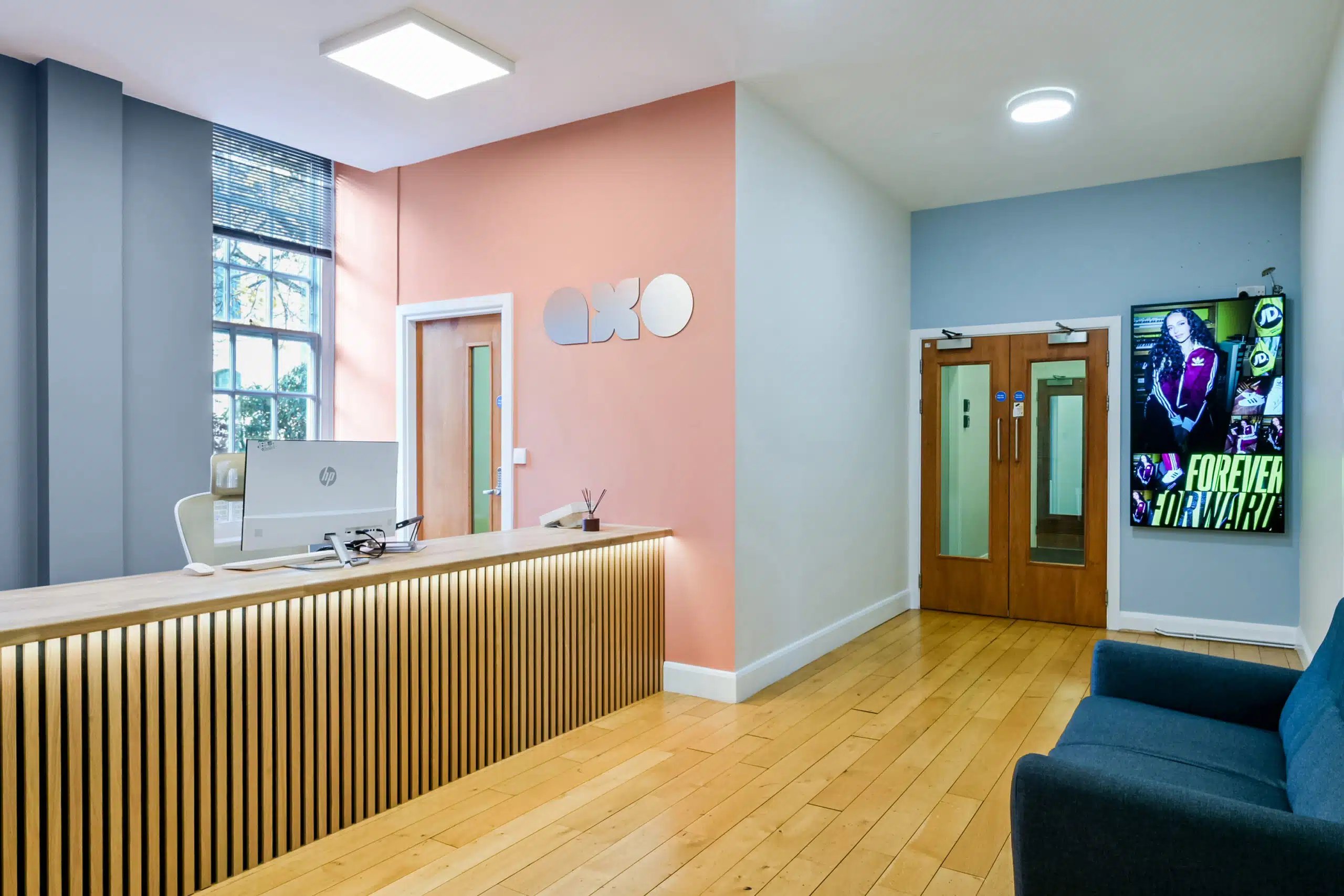 Reception desk with computer and sofa entrance area at AXO Waterloo in London Student Accommodation