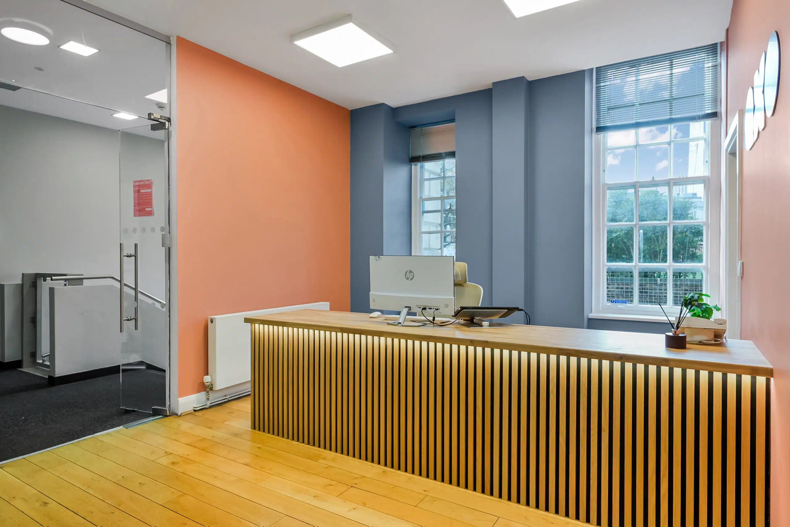 Desk with computer and plant reception area at AXO Waterloo in London Student Accommodation