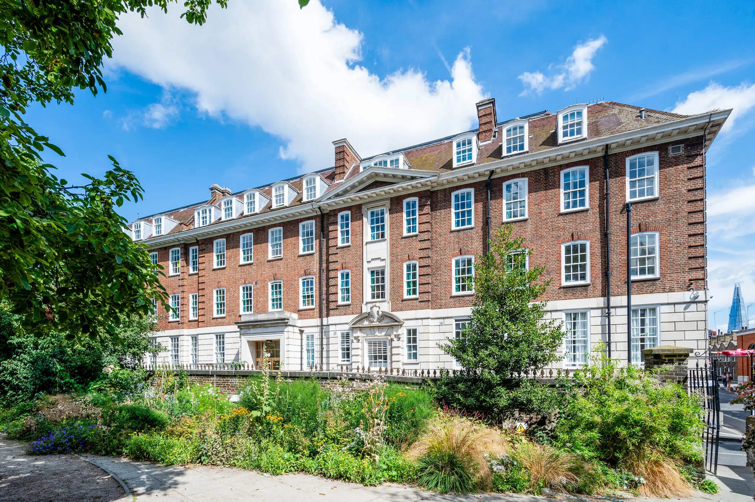 Brick building with gardens and trees exterior at AXO Waterloo in London Student Accommodation