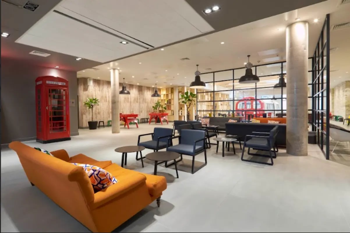 Sofa red phone booth seating area living room at Spring Mews in London Student Accommodation