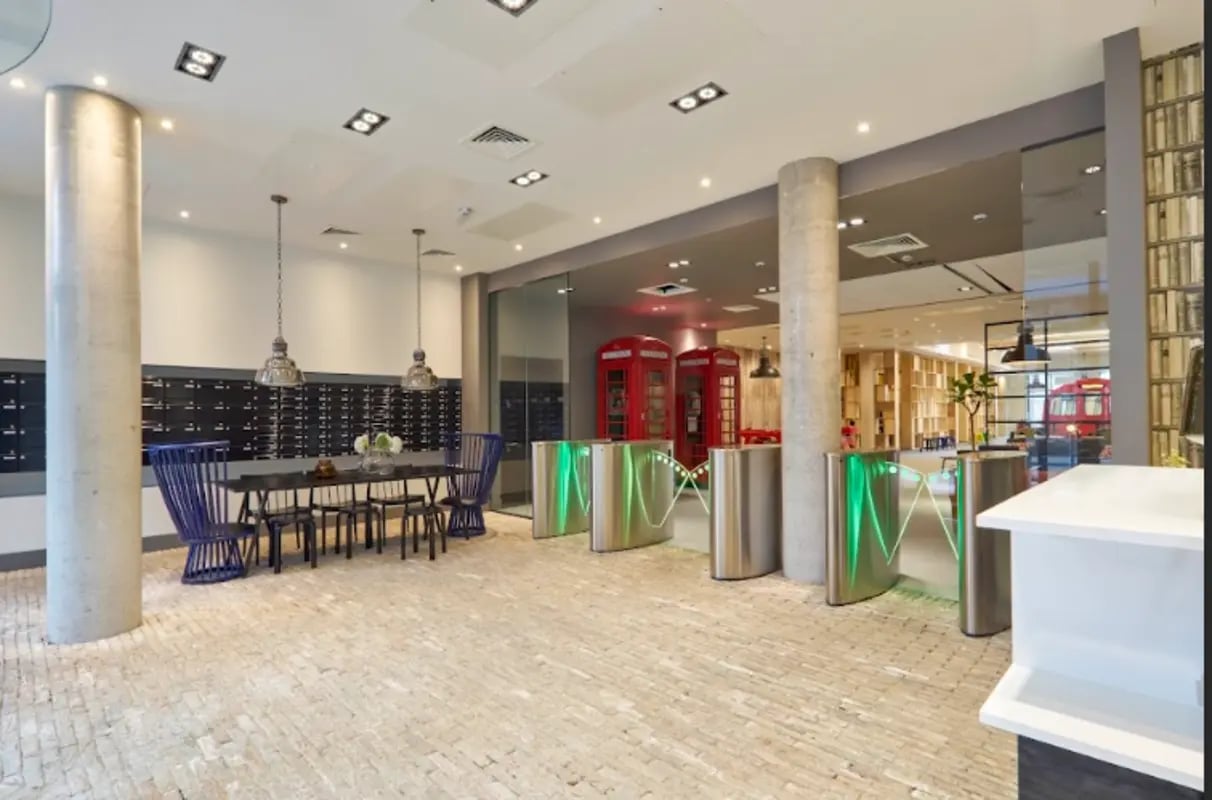 Mailboxes tables chairs turnstiles red phone booths lobby at Spring Mews in London Student Accommodation