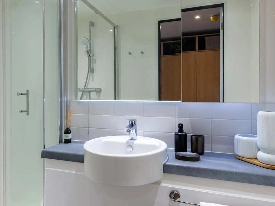 Sink shower and mirror with toiletries bathroom at The Gorge in Exeter Student Accommodation
