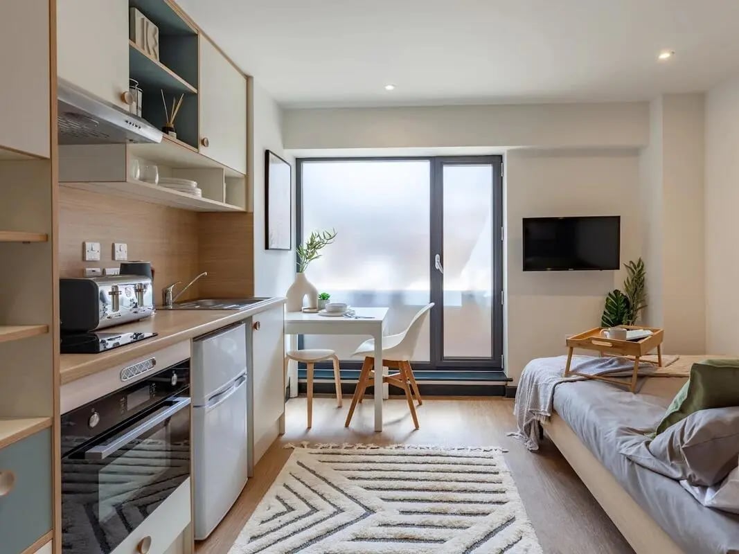 Kitchen with toaster oven fridge and dining area studio at The Gorge in Exeter Student Accommodation