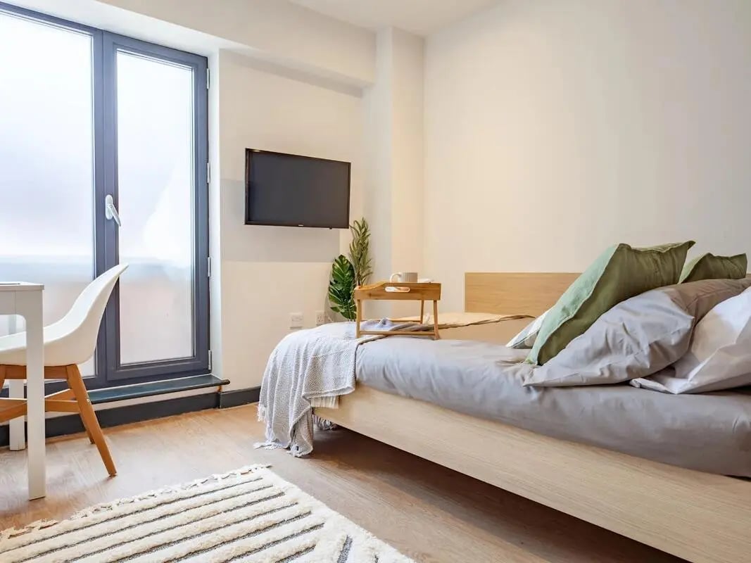Bed TV chair and rug bedroom at The Gorge in Exeter Student Accommodation