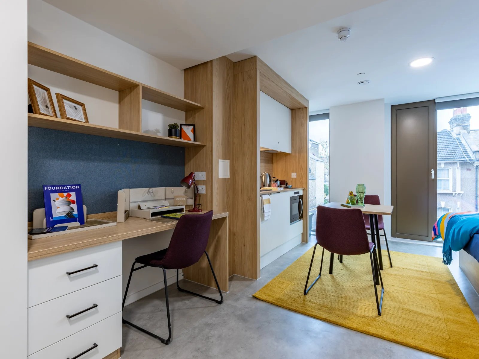 Desk chair kitchenette and dining area studio at Venti House in London Student Accommodation